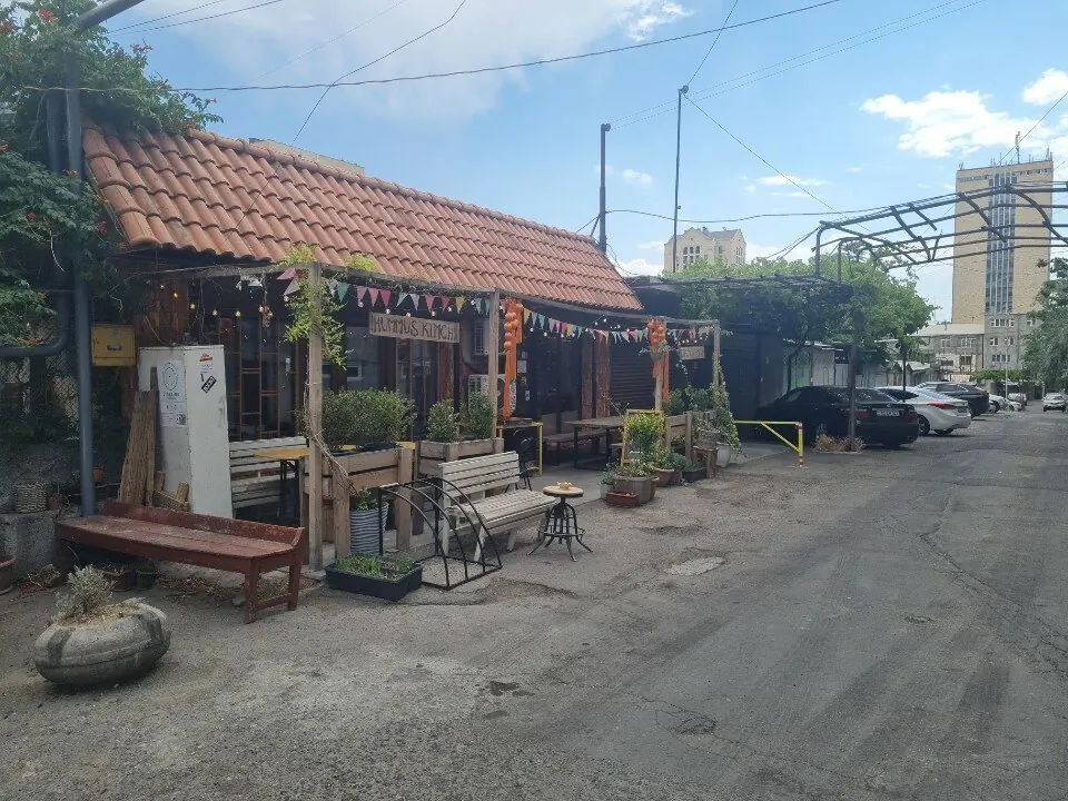 The garage lane off Saryan Street with the café's tiled roof, benches and plants